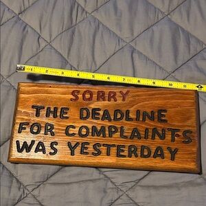 Wooden Sign with Black and Red Text